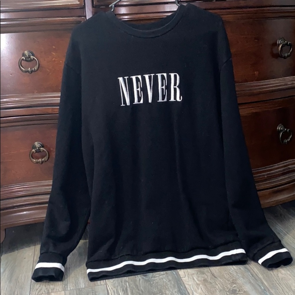 Black sweater with the word “never” on it